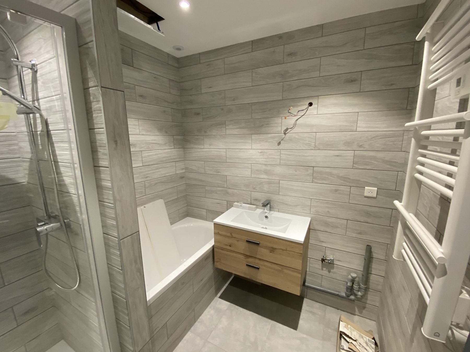 Salle de bains rénovée en carrelage effet bois gris