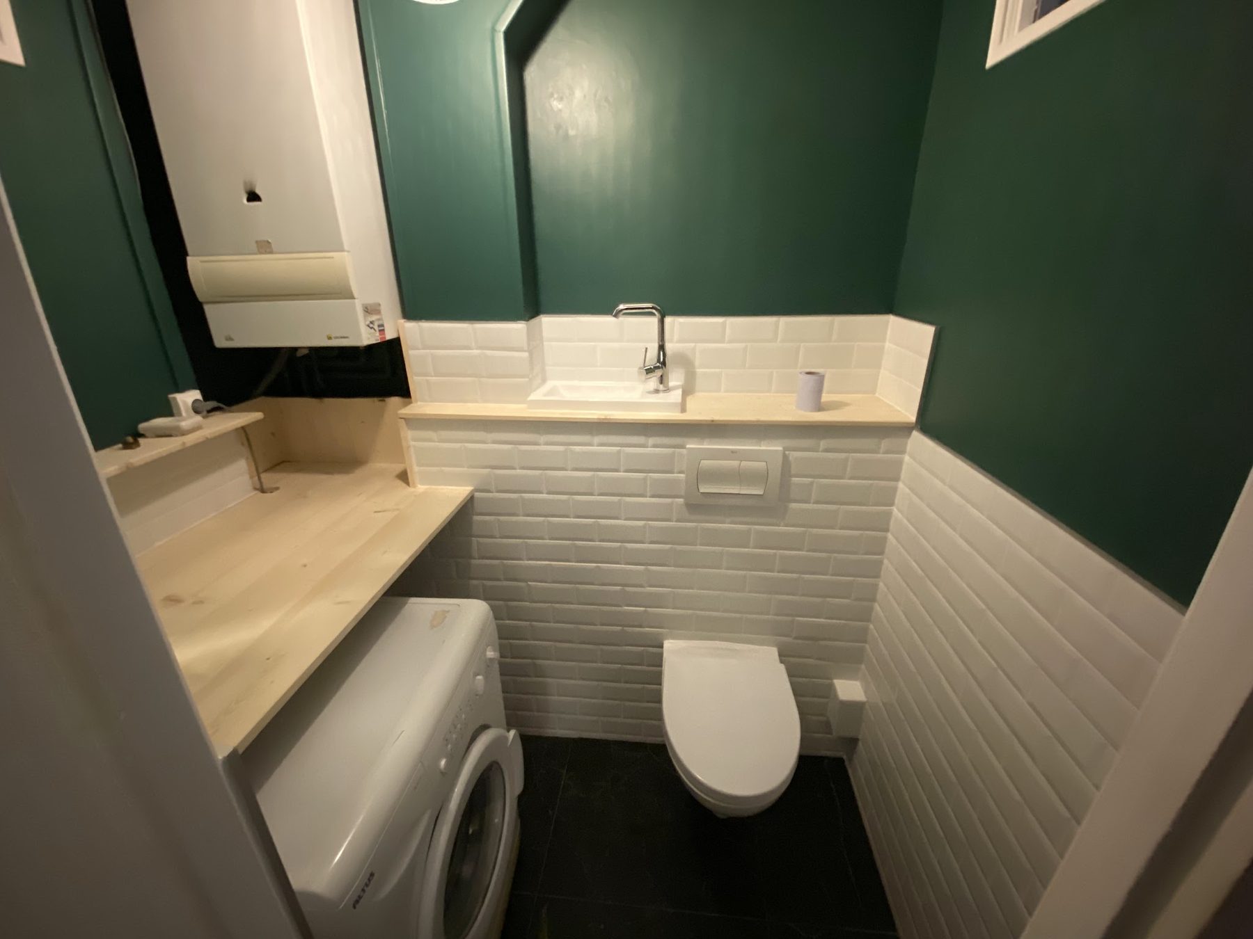 Toilettes rénovées, faïence métro et mur vert